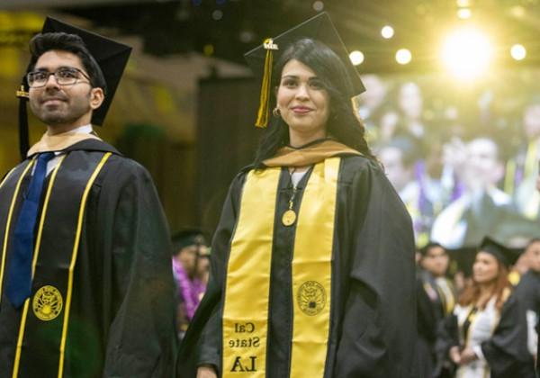 2 graduates at a graduation ceremony.